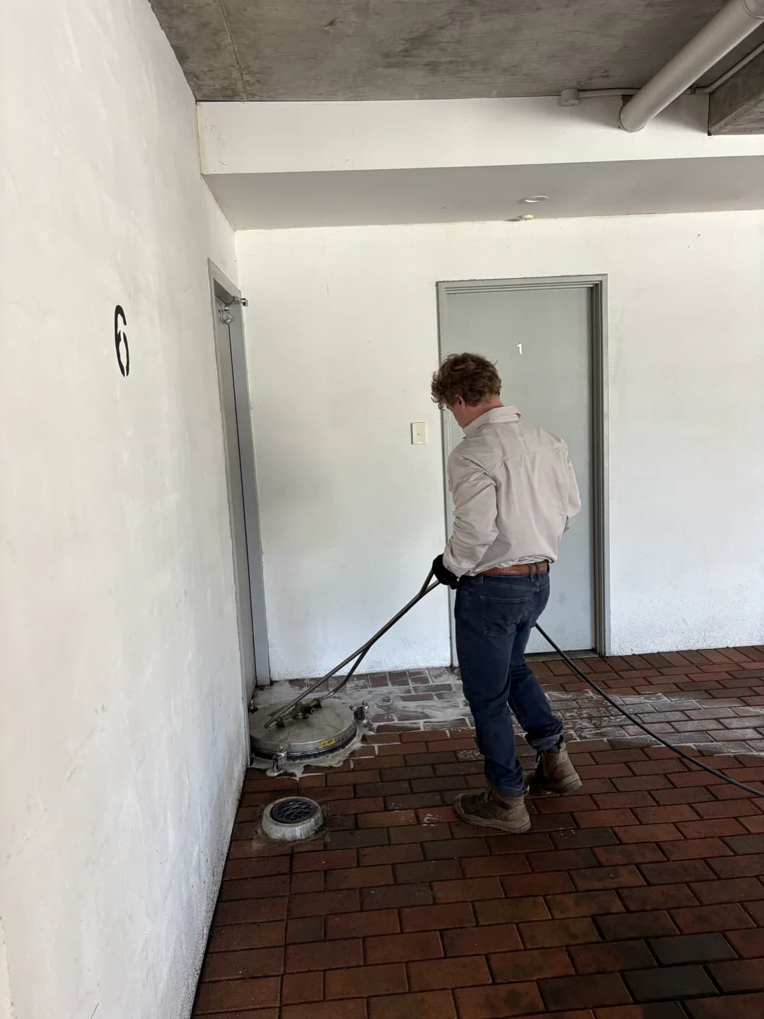Brick paver driveway restored to original red color after pressure washing in Fremantle