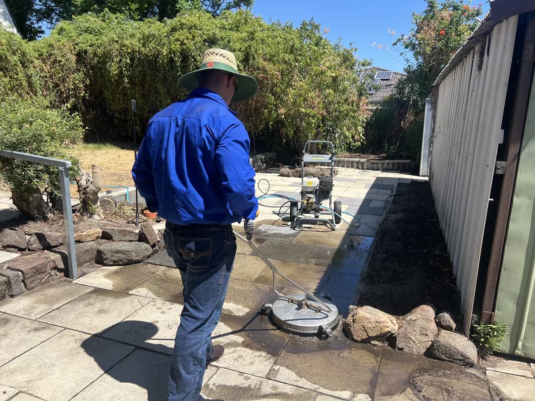 Grey concrete driveway with oil stains removed, uniform clean finish